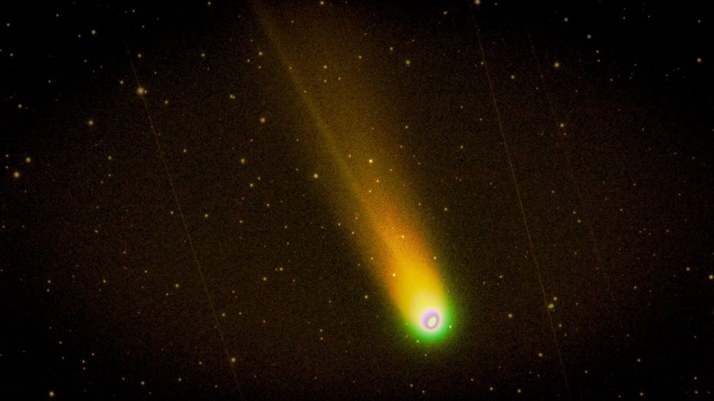 Cometa brilhante com uma cauda luminosa atravessando um céu noturno estrelado.