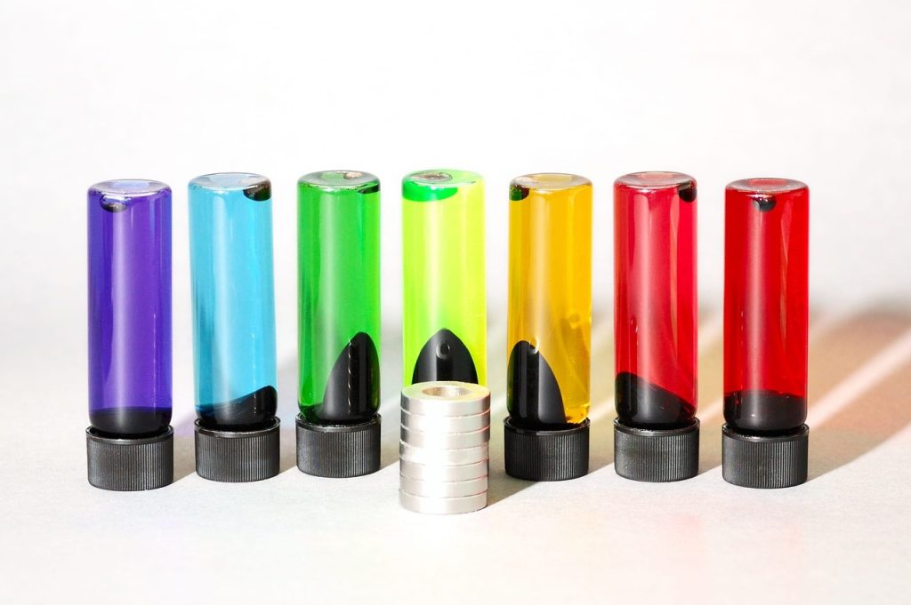 Ferrofluido colorido formando padrões ao redor de um ímã, em uma demonstração de magnetismo e nanotecnologia.